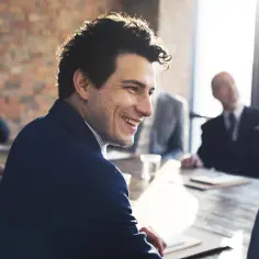 Uśmiechnięty mężczyzna na spotkaniu biznesowym. Czy można odbyć staż z urzędu pracy w tej samej firmie dwa razy?