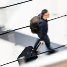 Mężczyzna z plecakiem i walizką spieszy się na lotnisko. Czy czas dojazdu na lotnisko wlicza się do czasu delegacji?