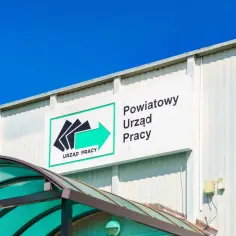 Znak "Powiatowy Urząd Pracy" nad zielonym zadaszeniem. Czy szukanie pracy przez urząd pracy to realna szansa dla specjalistów?