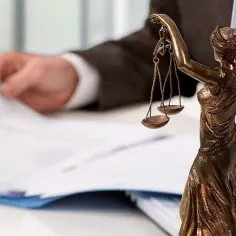 Staż u komornika lub notariusza: codzienna praca stażysty to przeglądanie dokumentów i dbanie o sprawiedliwość, symbolizowana przez wagę Temidy.