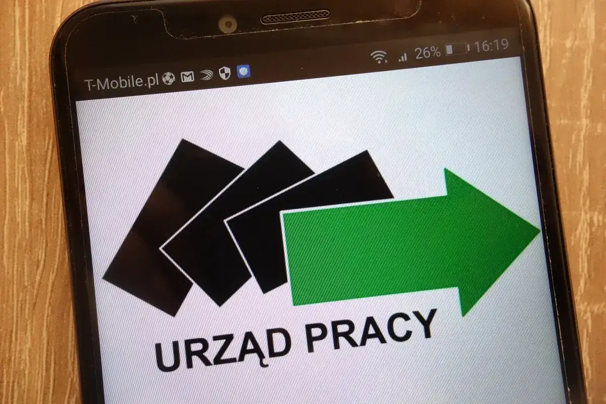 Staż z urzędu pracy: jak działa ubezpieczenie zdrowotne i ochrona NFZ. Logo urzędu pracy na ekranie telefonu.